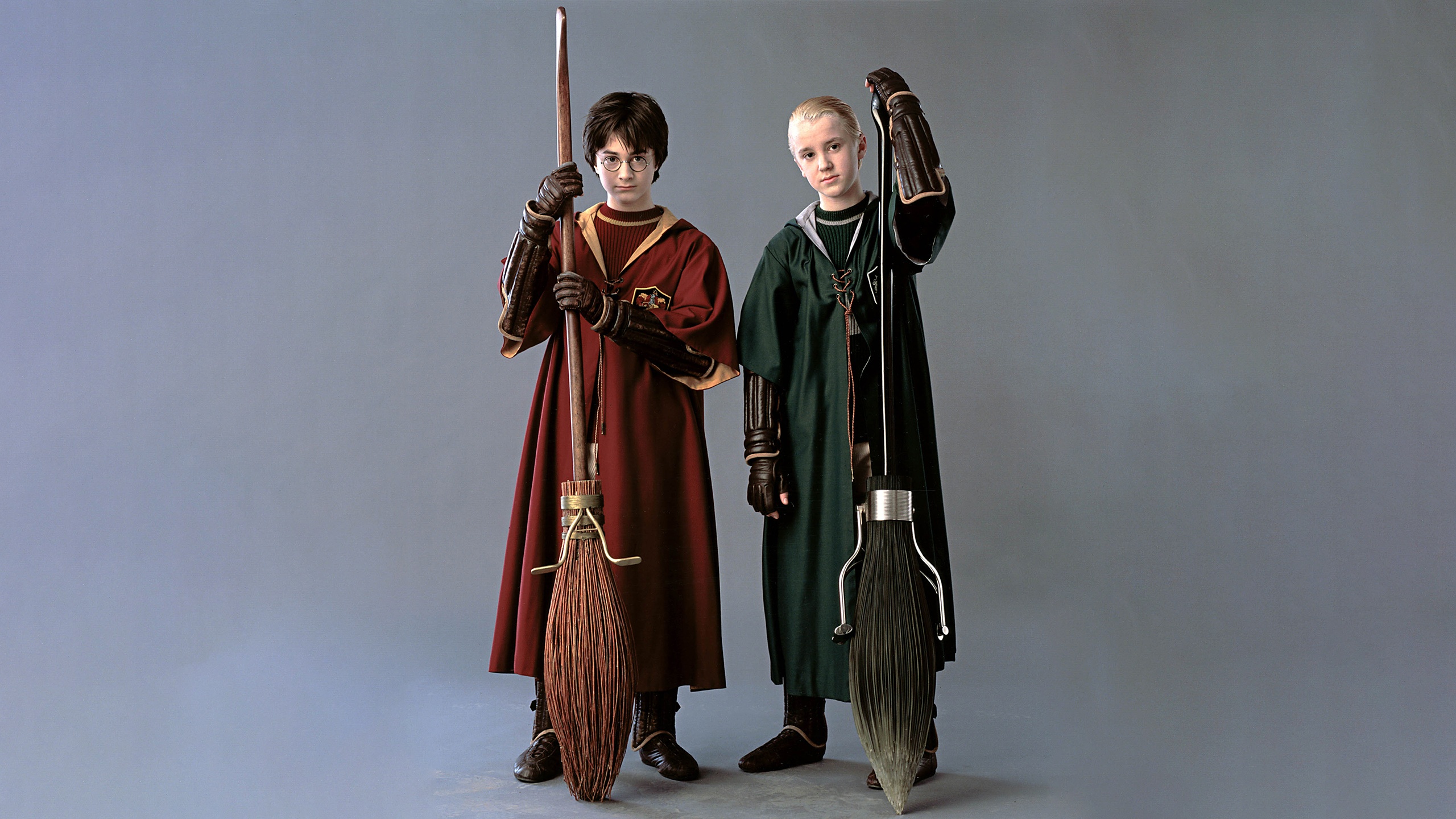 Обои Гарри и Драко в костюмах для квиддича и с метлами на рабочий. 